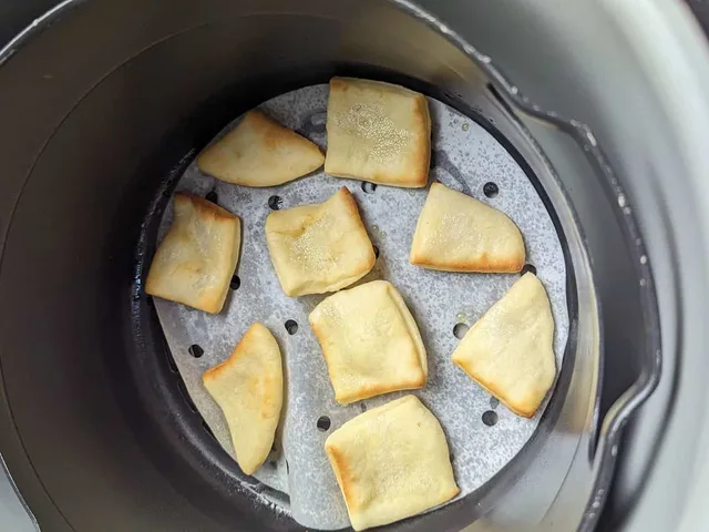 Air fryer mandazi mid-cooking, inside an air fryer.